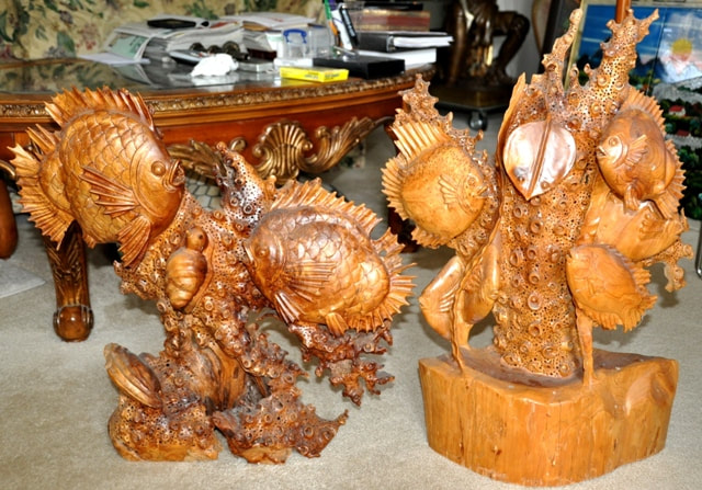 Wood carved sculptures of fish swimming in the ocean
