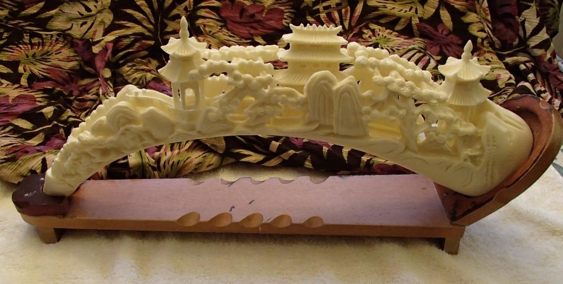 17 inchj long faux ivory carving of Oriental village on resin tusk