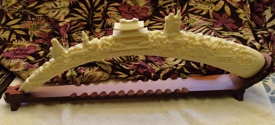 23 inch long faux ivory carving of Oriental village on resin tusk