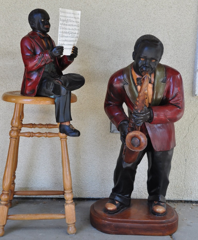 Polychrome decorated statues of a jazz band singer and a saxophone player