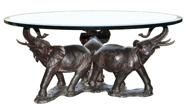 Glass top coffee table with bronze sculpture base depicting 3 elephants with their heads raised up and trunks swept back