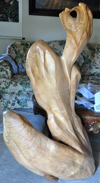 Abstract sculpture of a woman carved out of a large piece of wood