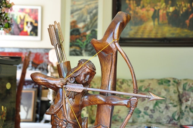 Wood carved sculpture of a Native American shooting an