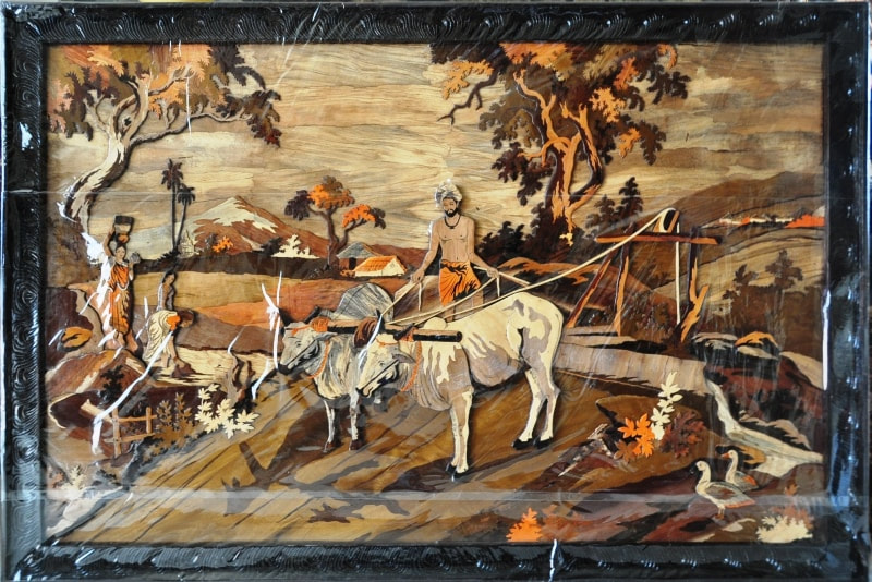 Large carved and inlaid wooden artwork from India depicting farming scenery