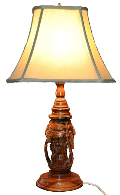 Table lamp with carved wooden base showing coconut palm and people