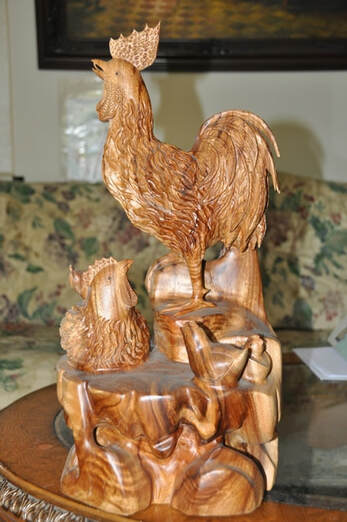 Wooden sculpture of a chicken family of a rooster, a hen and 3 chicks
