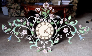 Antique ornate clock with a metal frame of vines, flowers and leaves 