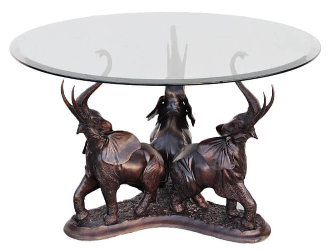 Glass top table with bronze sculpture base in the form of 3 elephants with raised trunks