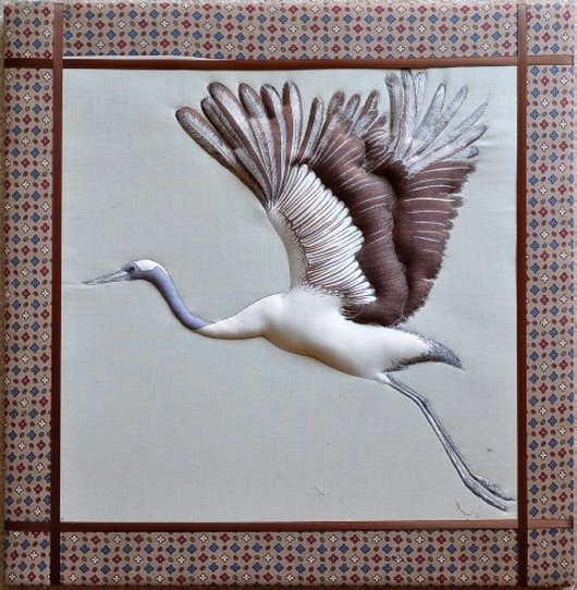 Wall hanging with soft sculpture of a flying crane made using fabric