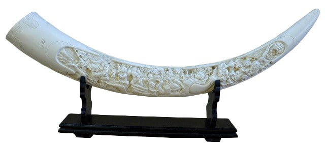 Large faux ivory tusk with relief carvings depicting Chinese mythological characters