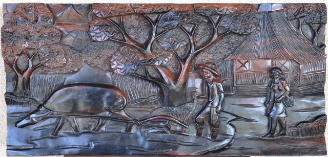 Kamagong wood panel with relief carving from the Philippines depicting a rural scenery
