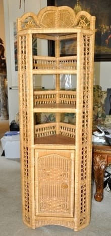 Wicker and wood corner stand of unique design with multiple shelves and a cabinet
