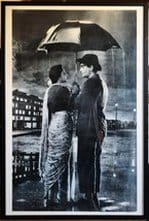 Poster of Nargis and Raj Kapoor standing under an umbrella in monsoon rain singing Pyar hua ikrar hua in the 1955 film Shree 420​