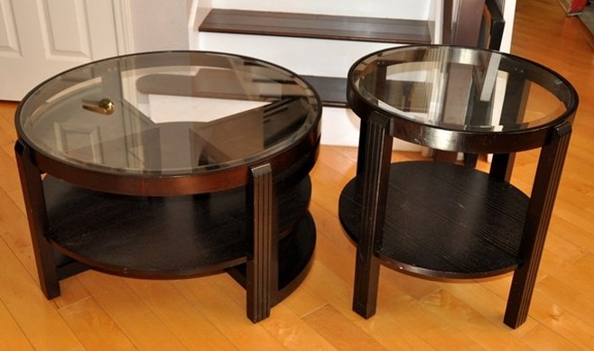Pair of circular wooden coffee and end tables with beveled glass tops