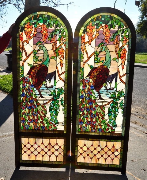 Pair of large stained glass windows depicting peacocks and vines